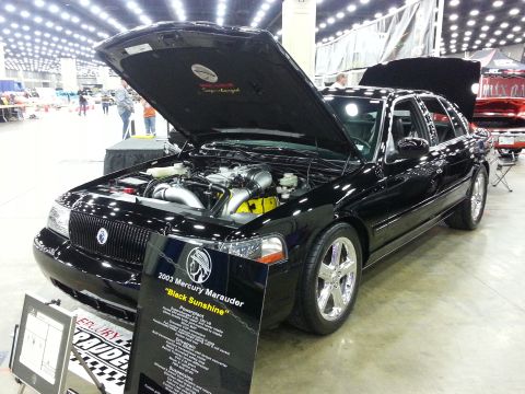 2003 Mercury Marauder - A black 2003 Mercury Marauder is displayed with its hood open, revealing the engine and a descriptive sign.