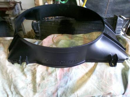 1982 Ford Bronco - A black plastic fan shroud with "CAUTION FAN" text is shown in front of a radiator.