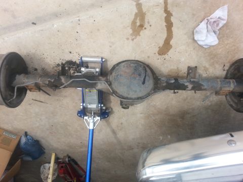 1982 Jeep Wagoneer - A vehicle's rear axle assembly is shown removed and supported by a floor jack.