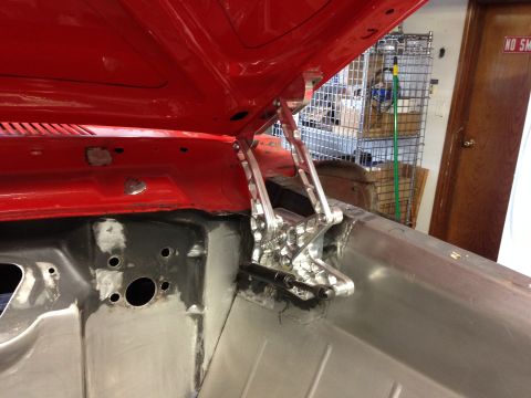 1964 Ford Fairlane - Close-up of aftermarket hood hinges installed on a vehicle's engine bay.