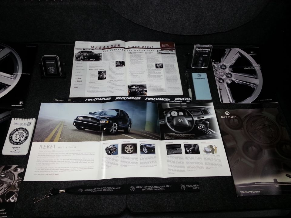 Promotional materials for a 2003 Mercury Marauder, including brochures and a wheel