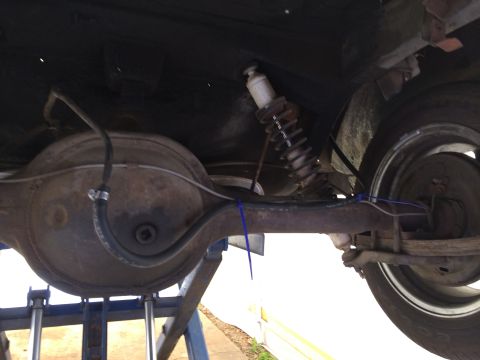 1964 Ford Ranchero - Underside view of a 1964 Ford Ranchero's rear axle, showing the shock absorber and suspension components.