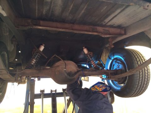 1964 Ford Ranchero - Underside view of a 1964 Ford Ranchero, focusing on the rear axle, leaf springs, and shock absorbers.