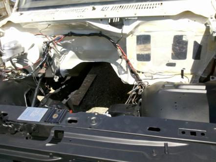 1982 Ford Bronco - The engine bay of a vehicle is shown with most of the engine components removed, revealing the chassis and wiring.