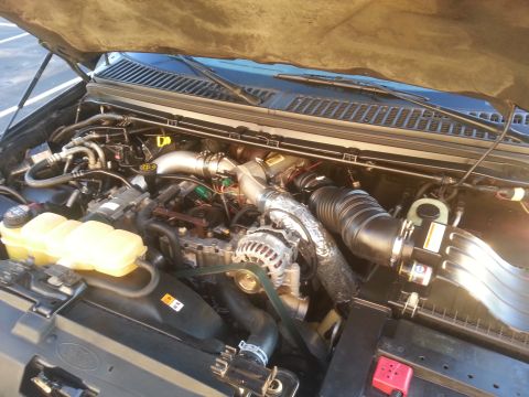 2001 Ford Excursion - The engine bay of a 2001 Ford Excursion is shown with the hood raised, revealing the engine components.