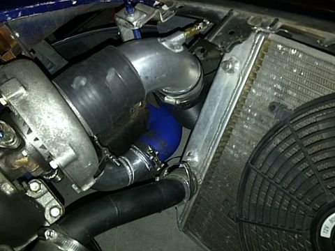 1995 Ford Probe - Close-up view of a turbocharger and radiator system in a vehicle engine bay.