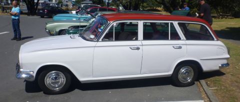 1969 Lincoln Continental - A white station wagon with a red roof is parked outdoors, with other vehicles in the background.