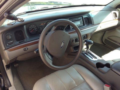 2007 Ford Crown Victoria - The interior of a 2007 Ford Crown Victoria features a tan leather interior with a wood-grain trim dashboard.