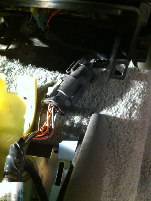 2007 Ford Crown Victoria - Close-up view of a disconnected wiring harness connector and exposed wires located beneath the vehicle's interior seating.