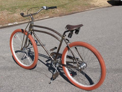 Brown bicycle with orange tires and a brown leather seat