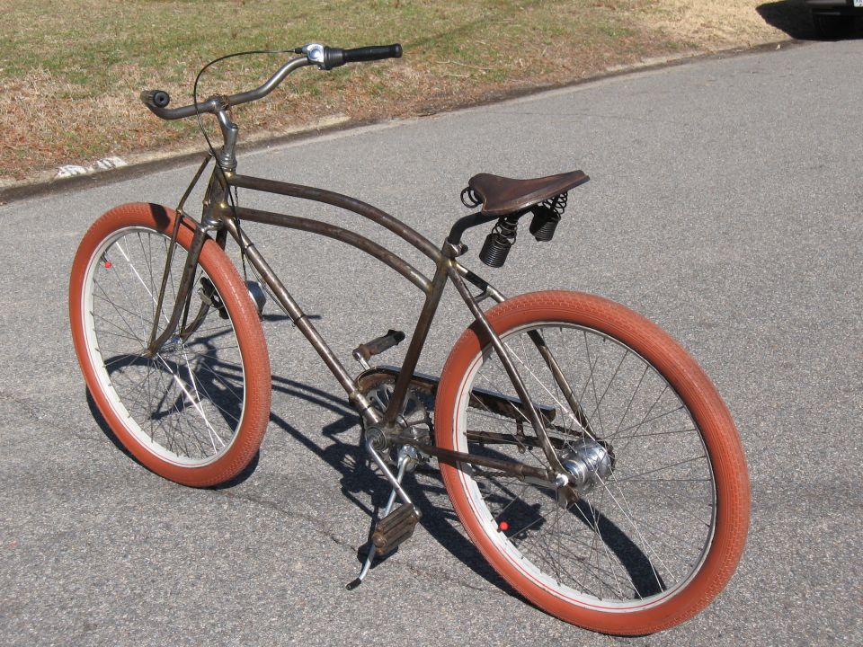 Brown bicycle with orange tires and a brown leather seat