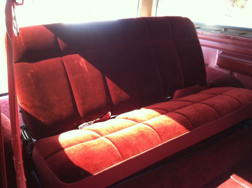 Red velour rear bench seat with quilted pattern and seatbelt