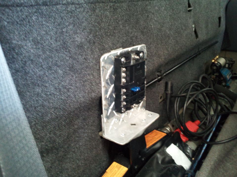 Fuse block with wiring mounted on diamond plate bracket inside vehicle