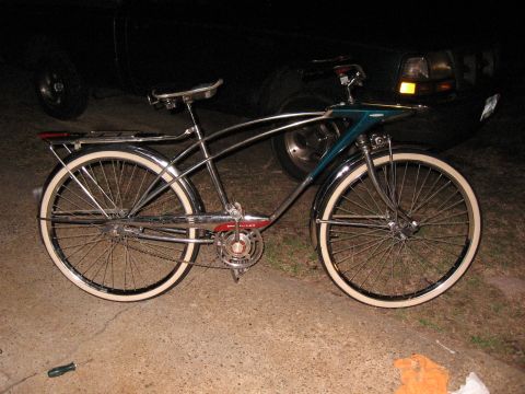 1994 Ford Bronco - A classic bicycle with chrome accents and whitewall tires is parked in front of a dark-colored truck.