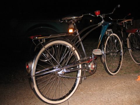 1994 Ford Bronco - Two vintage bicycles with whitewall tires are parked outside at night.