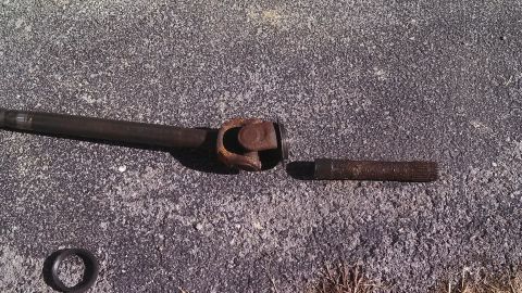 1979 Ford Bronco - A broken driveshaft component lies on the ground next to a universal joint.