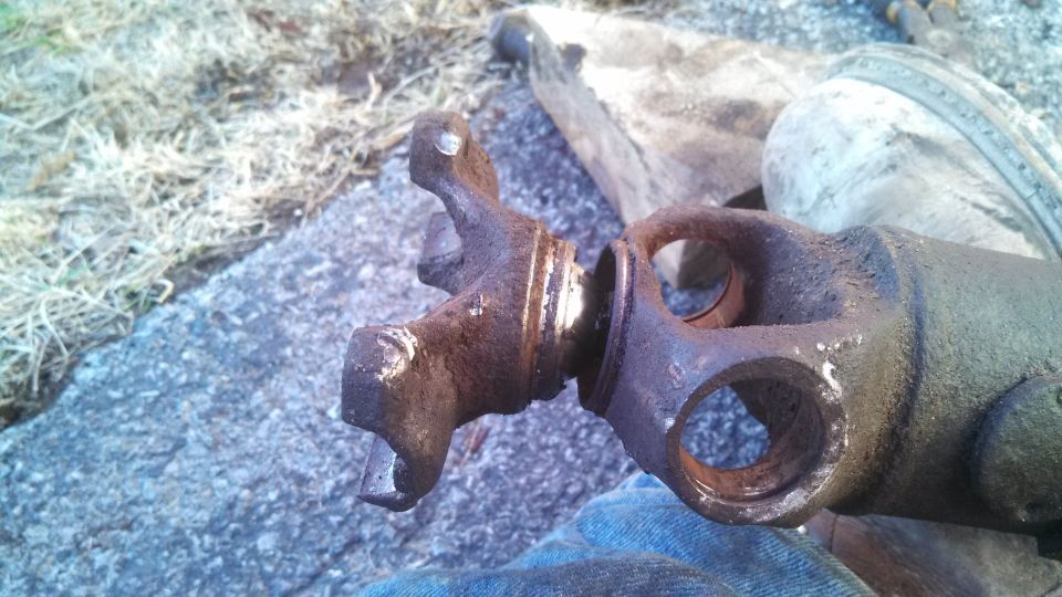 Rusty driveshaft U-joint and yoke assembly, showing wear and corrosion