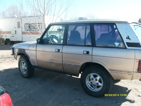 1991 Land Rover Range Rover - Side view of a 1991 Land Rover Range Rover parked on dirt ground.