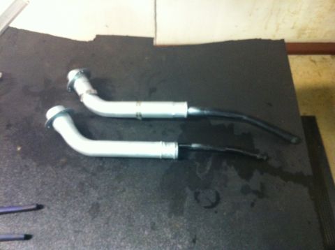 1982 Ford Bronco - Two fuel filler necks are shown on a dark surface, possibly for a vehicle repair or parts identification.