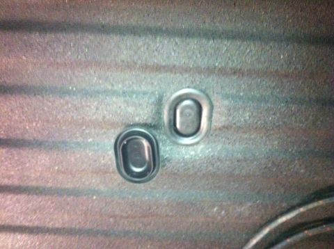 1982 Ford Bronco - Close-up view of two oval grommets set into a textured surface.