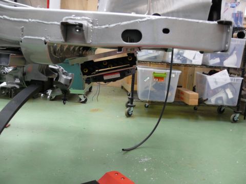 Close-up of a car's frame and suspension components, possibly during restoration or repair