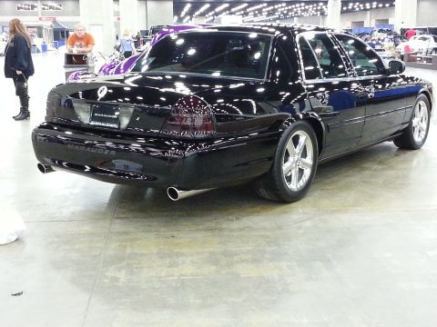 2003 Mercury Marauder - A black 2003 Mercury Marauder is displayed at a car show, custom wheels and tinted taillights.