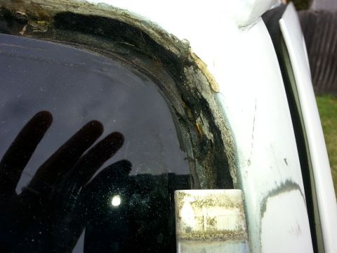1992 Ford Bronco - Corroded window seal showing significant rust and deterioration around the glass edge.