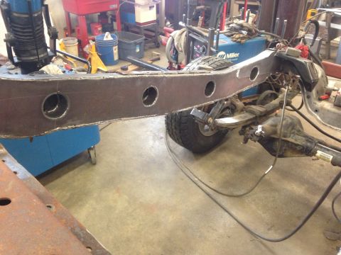1993 Ford Bronco - Close-up view of vehicle frame and suspension parts during repair or modification in a workshop setting.