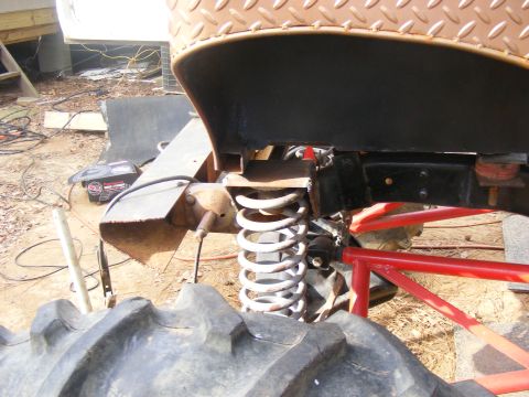Close-up of off-road suspension with large tire and diamond plate fender