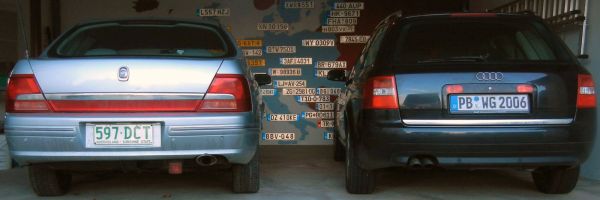 Rear view of a silver sedan and a black Audi wagon parked side-by-side