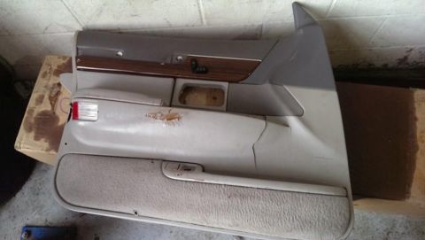 2000 Mercury Grand Marquis - A detached car door panel is shown, faux wood trim and a damaged section on the armrest.
