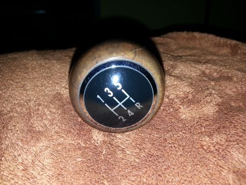 2002 Volkswagen Jetta - A wooden gear shift knob with a 5-speed manual pattern is shown against a textured background.