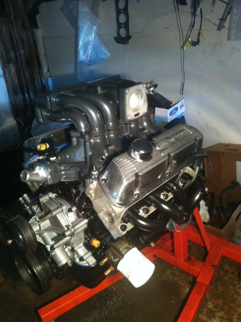 1992 Ford Bronco - Ford V8 engine assembly on a red engine stand, likely undergoing a rebuild or modification.