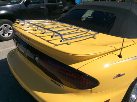 1968 Ford Mustang - Yellow convertible with a chrome luggage rack is parked next to a black SUV.