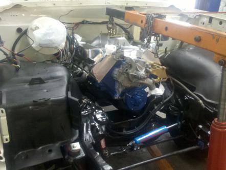 1982 Ford Bronco - An engine is suspended by an engine hoist, undergoing installation or removal. The SuperMotors logo is visible at the bottom right.