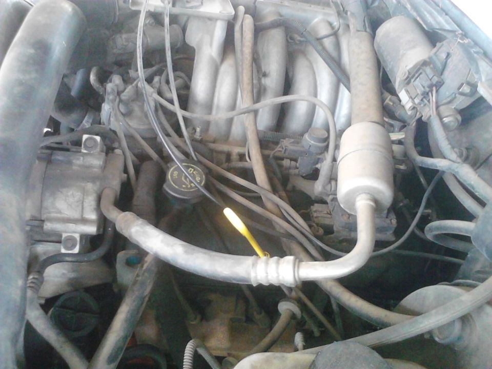 Engine bay with oil dipstick and AC components visible