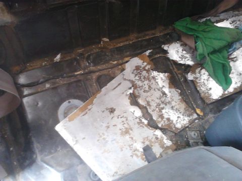 1990 Ford Bronco - Vehicle interior showing signs of wear and tear, with parts of the floor and panels damaged.