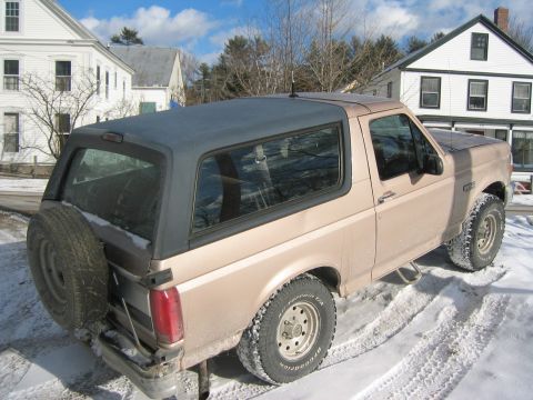 1996 Ford Bronco - This 1996 Ford Bronco is seen in a snowy residential area, its signature removable top and rear-mounted spare tire.