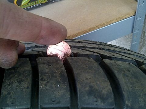 1993 Ford Probe - A penny is used to measure the tread depth of a tire.