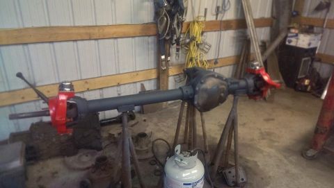 1995 Ford Bronco - A differential axle assembly is shown mounted on stands, with various tools and equipment in the background.