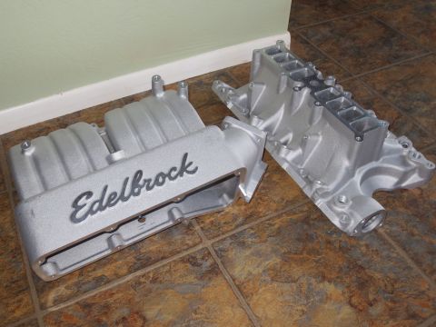 1996 Ford Bronco - Two Edelbrock intake manifolds are shown on a tiled floor, one with the brand name clearly visible.