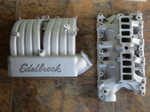 1996 Ford Bronco - Two aluminum intake manifolds, one with 'Edelbrock' branding, are displayed on a tiled surface.