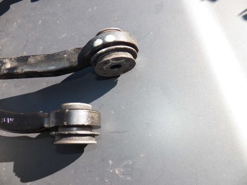 1998 Lincoln Mark VIII - Close-up of two automotive suspension control arm bushings, showing wear and part identification.