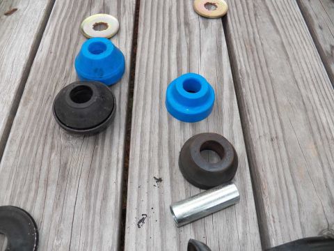 1998 Lincoln Mark VIII - Suspension bushings and hardware laid out on a wooden surface.