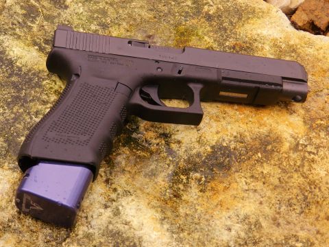1996 Ford Bronco - Glock pistol with extended magazine on a rock surface.