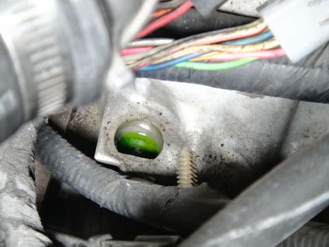 1993 Ford Taurus - Engine coolant leak observed in a metal component, with visible wiring harness in the background.