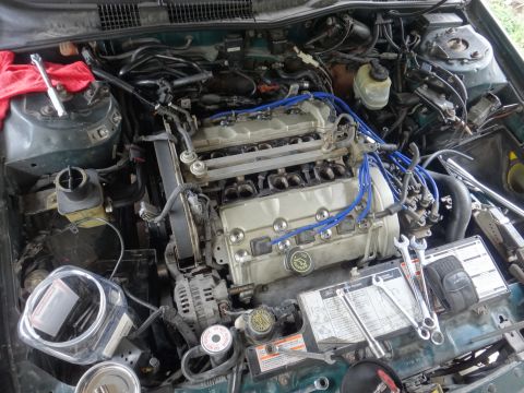 1993 Ford Taurus - Engine bay of a Ford vehicle, likely undergoing maintenance, with tools laid out.