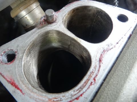 1993 Ford Taurus - A close-up view of an engine part, likely an intake manifold, showing two large ports and some red sealant.