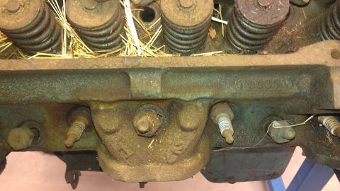 1970 Pontiac Trans Am - This image shows a close-up view of an engine's cylinder head, spark plugs and valve springs with some straw debris.