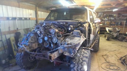 1995 Ford Bronco - This Ford Bronco is in a garage with its front end removed for repairs, showing the engine and other components.